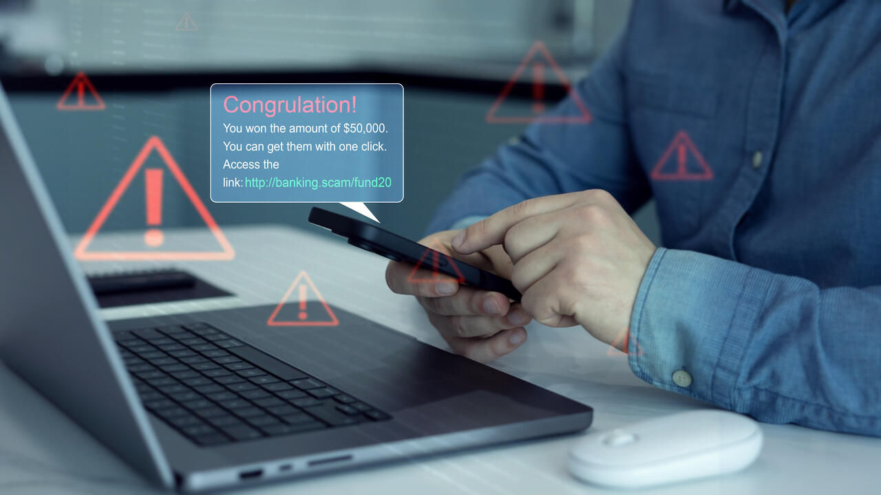 Close up hands holding phone with scam message on digital screen.Bank fraud through phone messages.Fake text SMS scam.Scammers online.Cyber scam