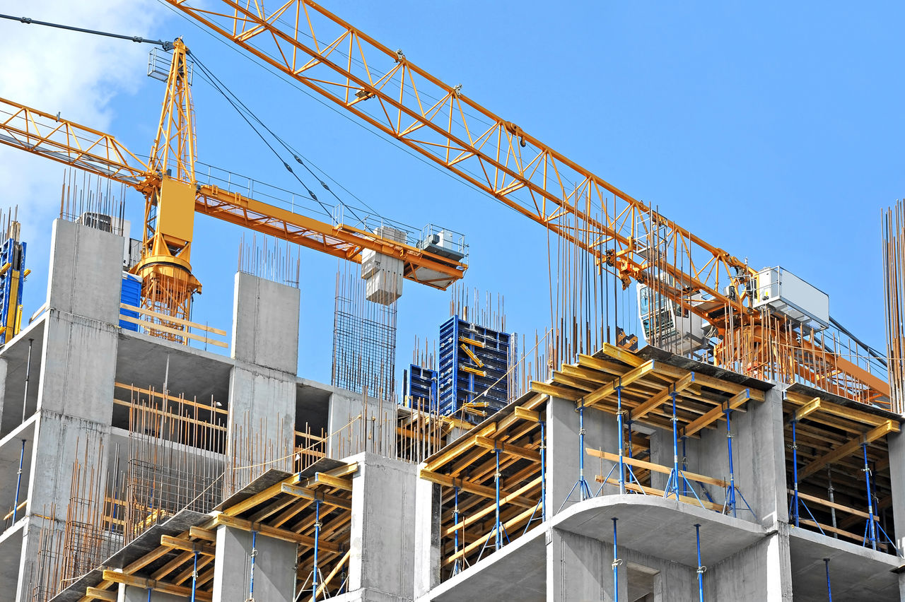 Crane and building construction site against blue sky